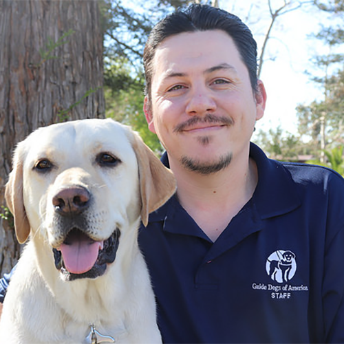 Headshot of Chris Medina sitting with a Yellow Lab dog.