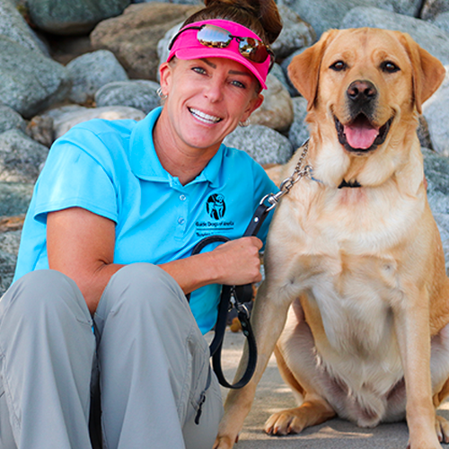 Headshot of Mindy Romero sitting outside with a Yellow Lab dog.