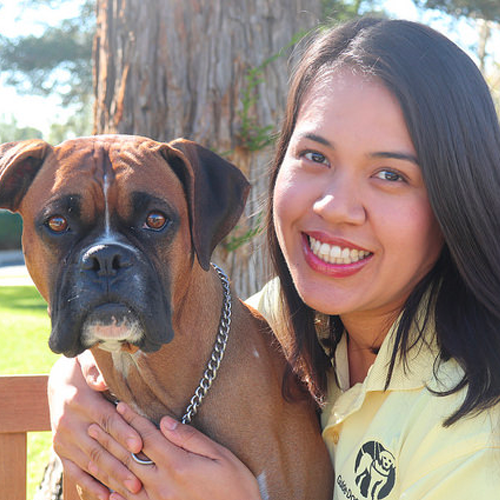 Headshot of Nataly Diaz sitting outside with a Boxer dog.