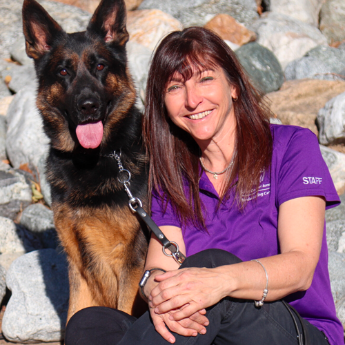 Headshot of Sonia Parisi sitting outside with a German Sheperd dog.