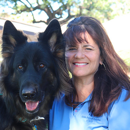 Headshot of Yvette Sheehan sitting with a German Sheperd dog.