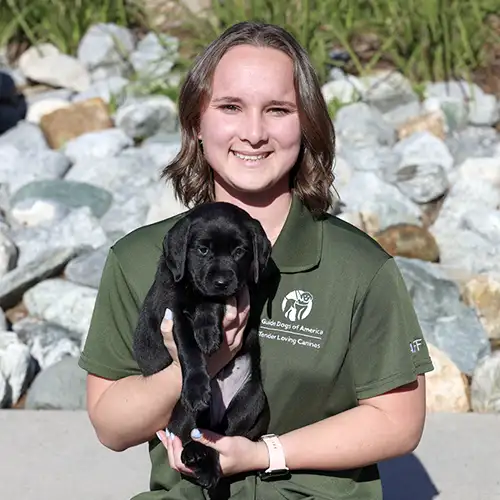 Headshot of Natalie Hooper holding a Black Lab puppy.