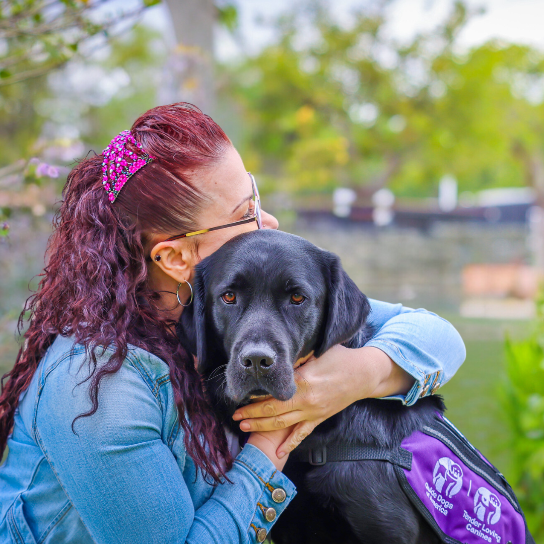 Woman hugging service dog.