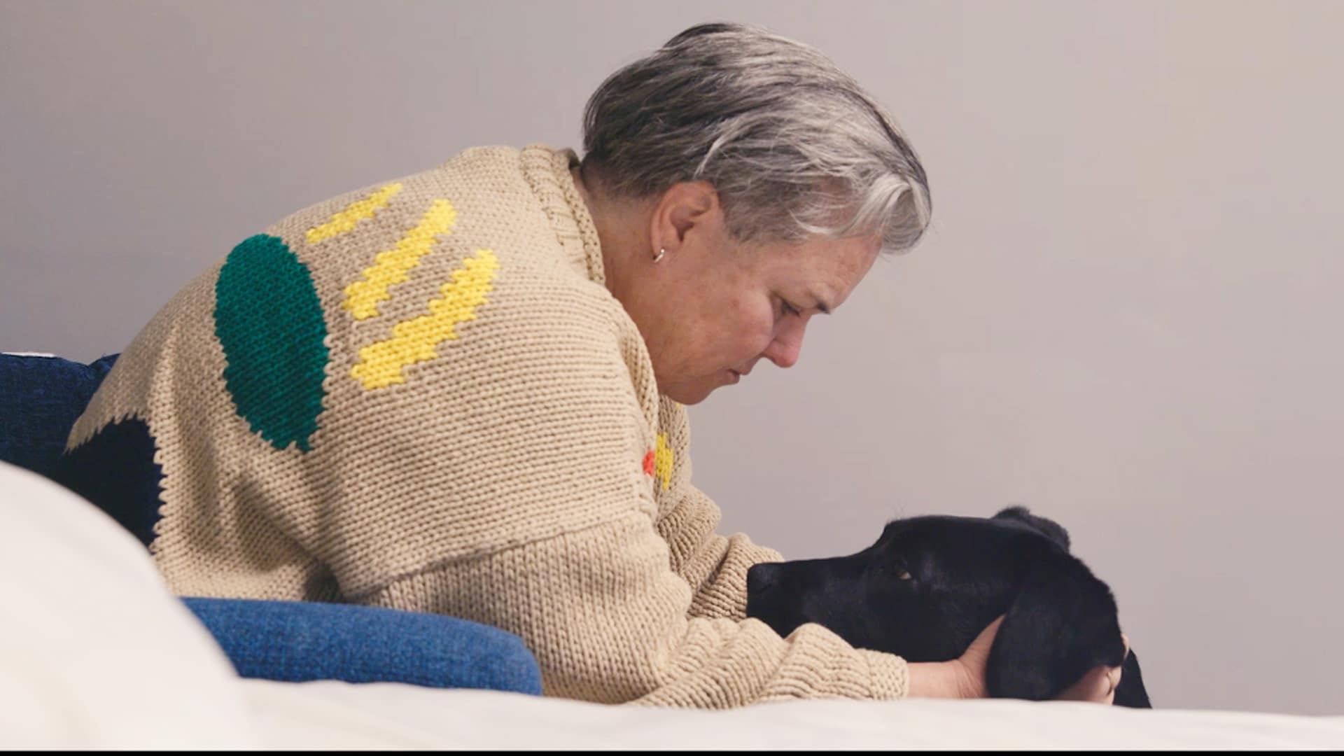 In a scene during the documentary Unleashing Hope, Rosie O'Donnell pets Kuma, the service dog and black labrador retriever, behind the ears and looks into the dog's eyes.