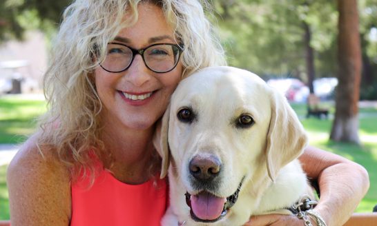 Lorri Bernson hugs her yellow Lab Captain